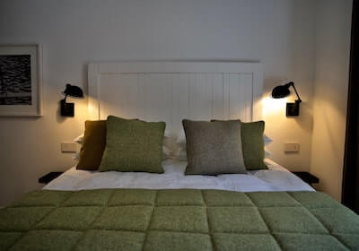 Dettaglio letto con testata del letto, cuscini e lampade