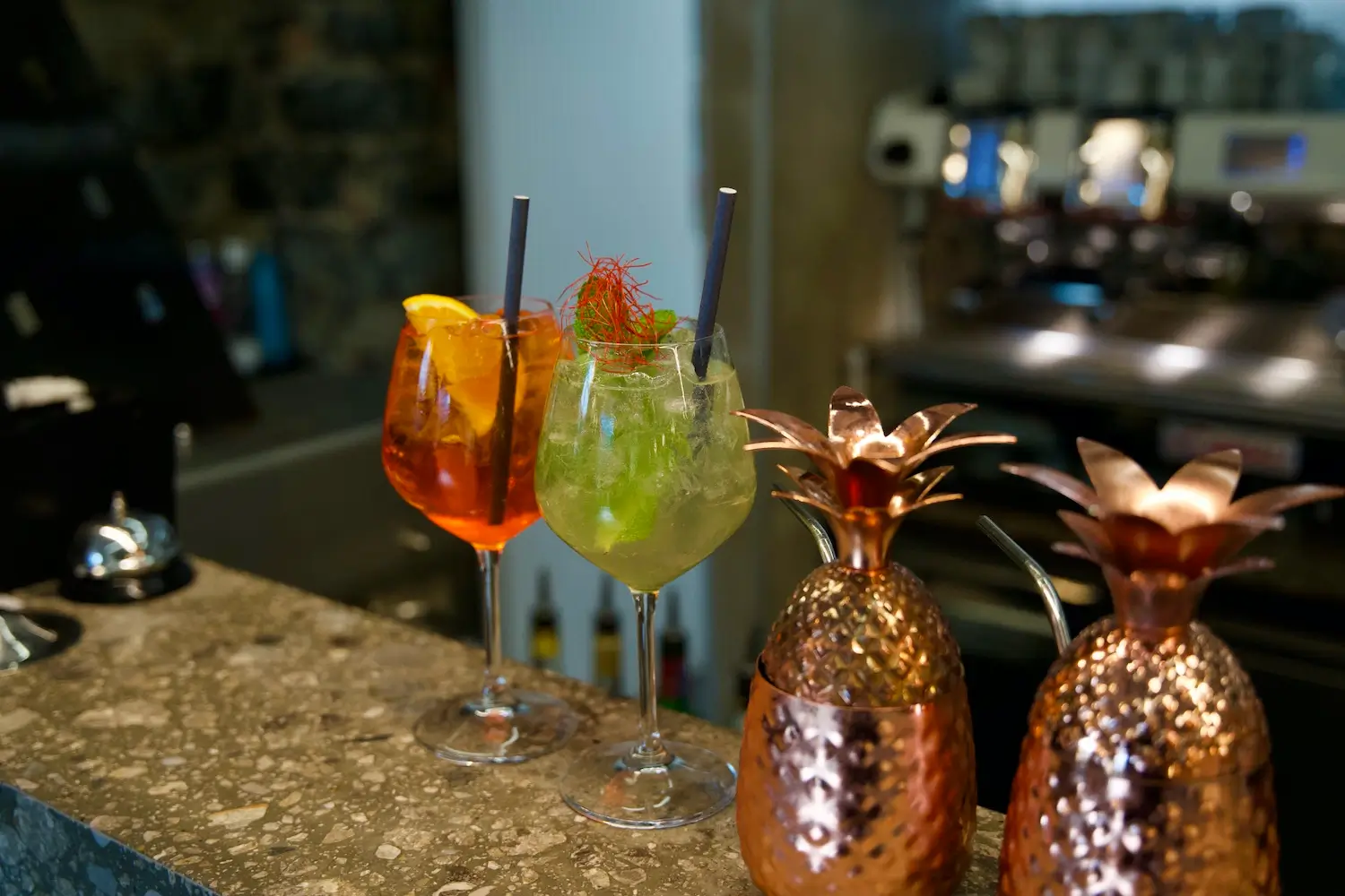 bancone del bar con due cocktail e due elementi decorativi in rame